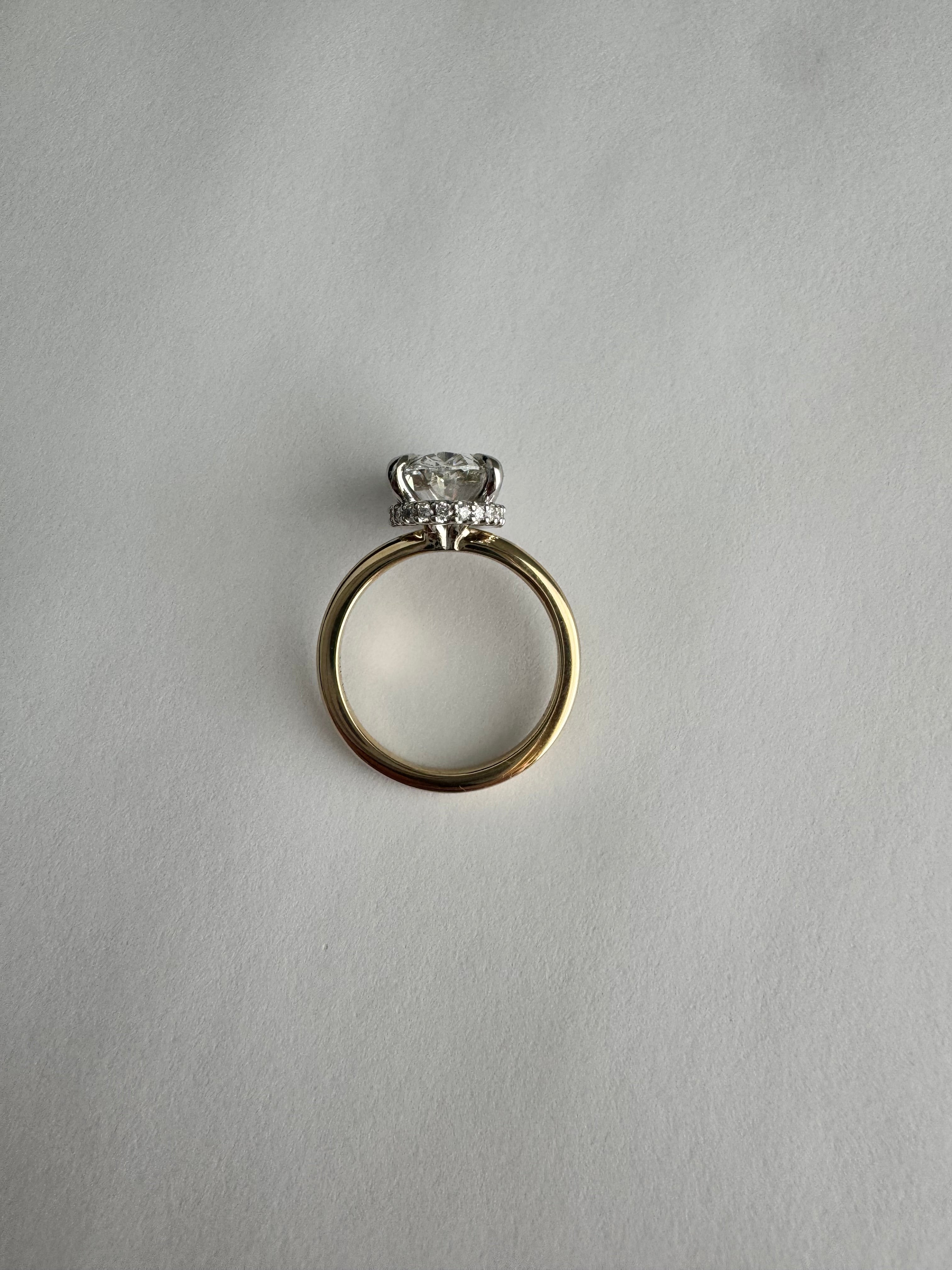 Custom, 14k yellow gold engagement ring with 14k white gold hidden halo 4 prong head. 3.03 ct lab grown oval diamond center (D, VS1). Size 5.