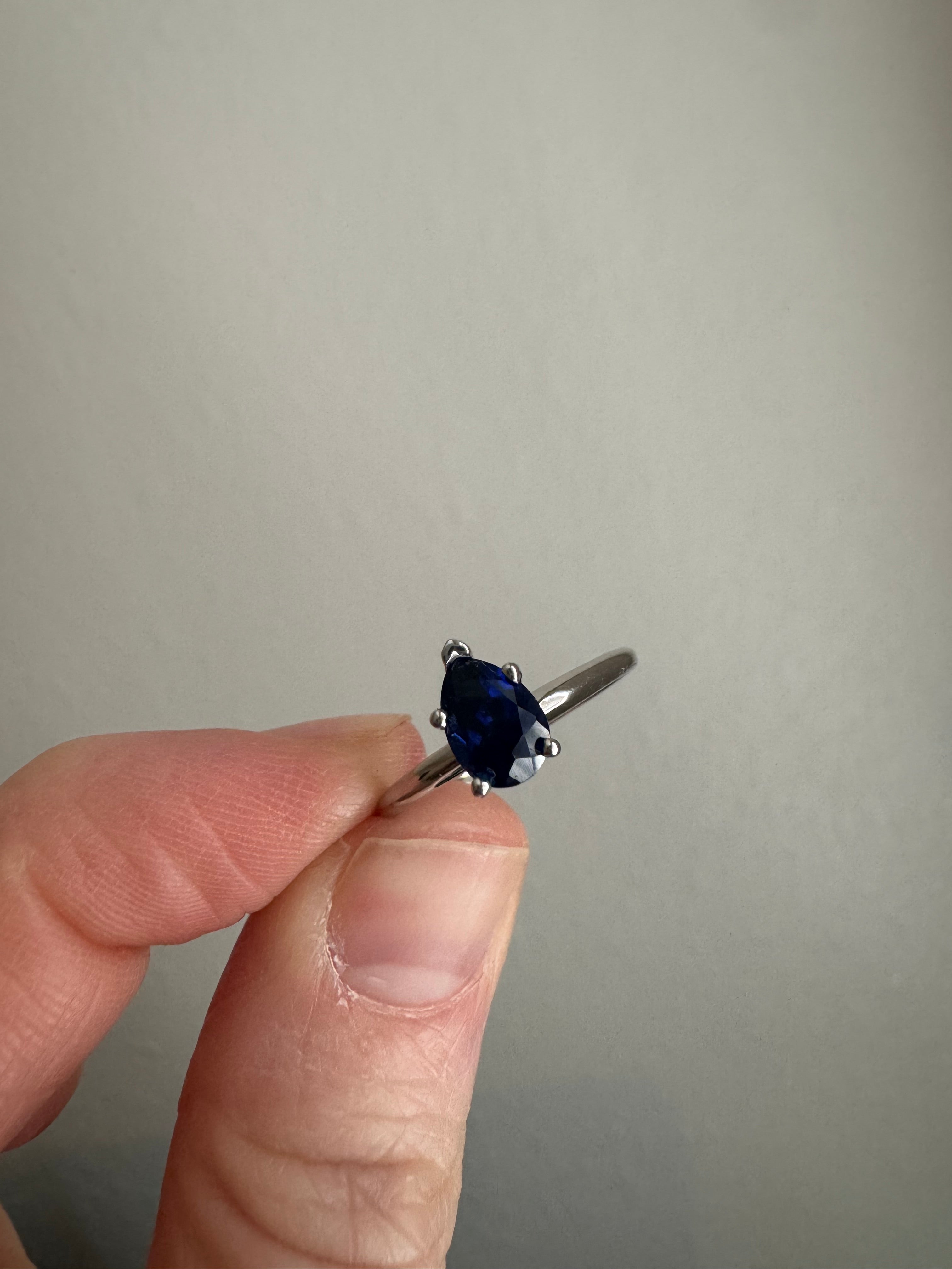 Set customer's lab grown pear shaped blue sapphire (7x5mm) in 14k white gold solitaire setting. Size 7.