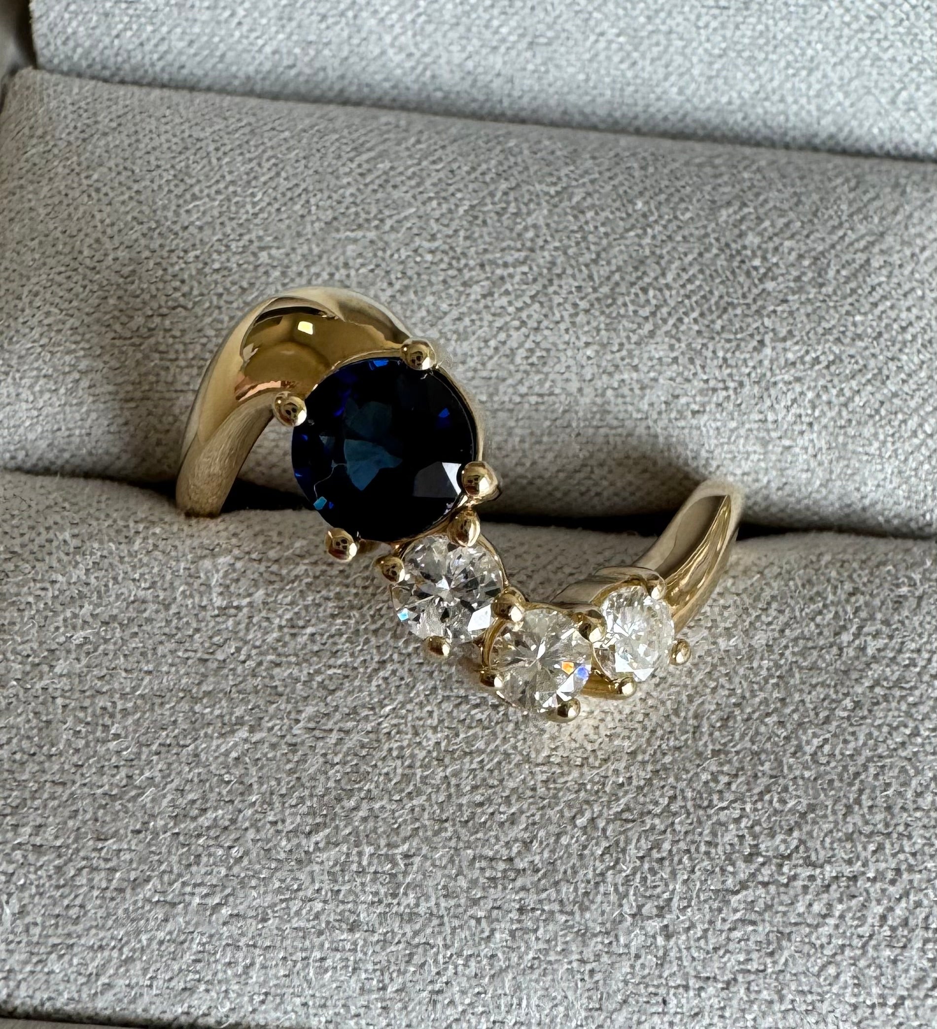 Custom 10k yellow gold wave style ring with 1 round sapphire & 3 round diamonds (sapphire= 1.04 cts, dias= 0.19 cts, 0.15 cts, 0.21 cts) Size 10.