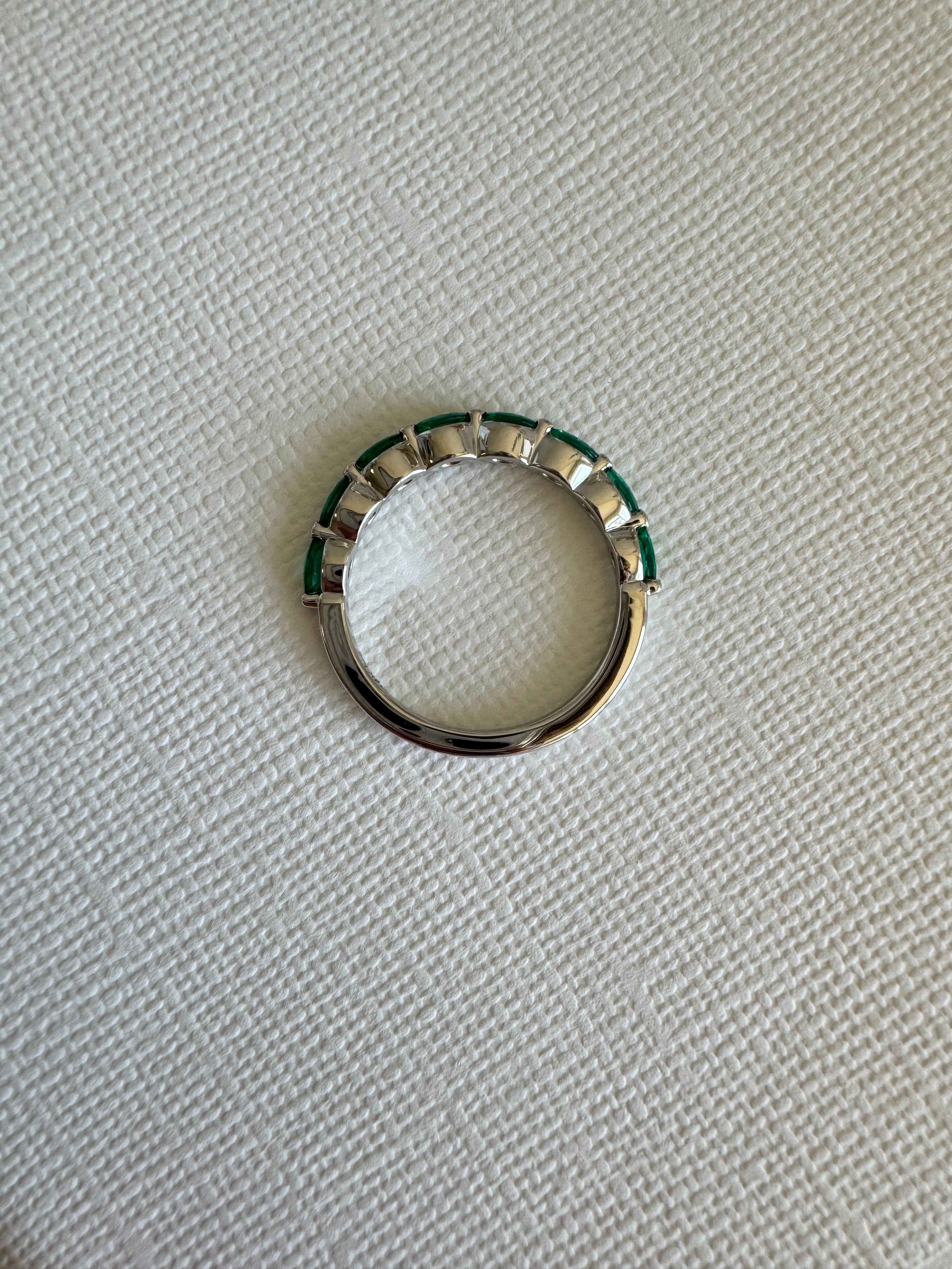Custom, 14k white gold band with 8, lab grown marquise shaped emeralds (4x2mm) totaling approx. .48 carats. Size 7.5.