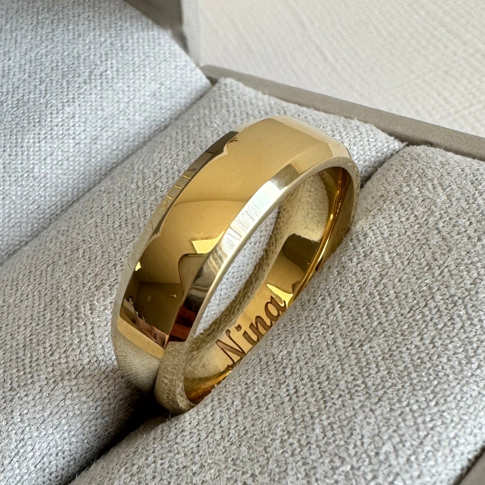10K Yellow Gold, 6 mm Beveled-Edge, Comfort-Fit, Half Round Band. Size 8.5. The inside is engraved with "Nina" in a Script MT Bold font.