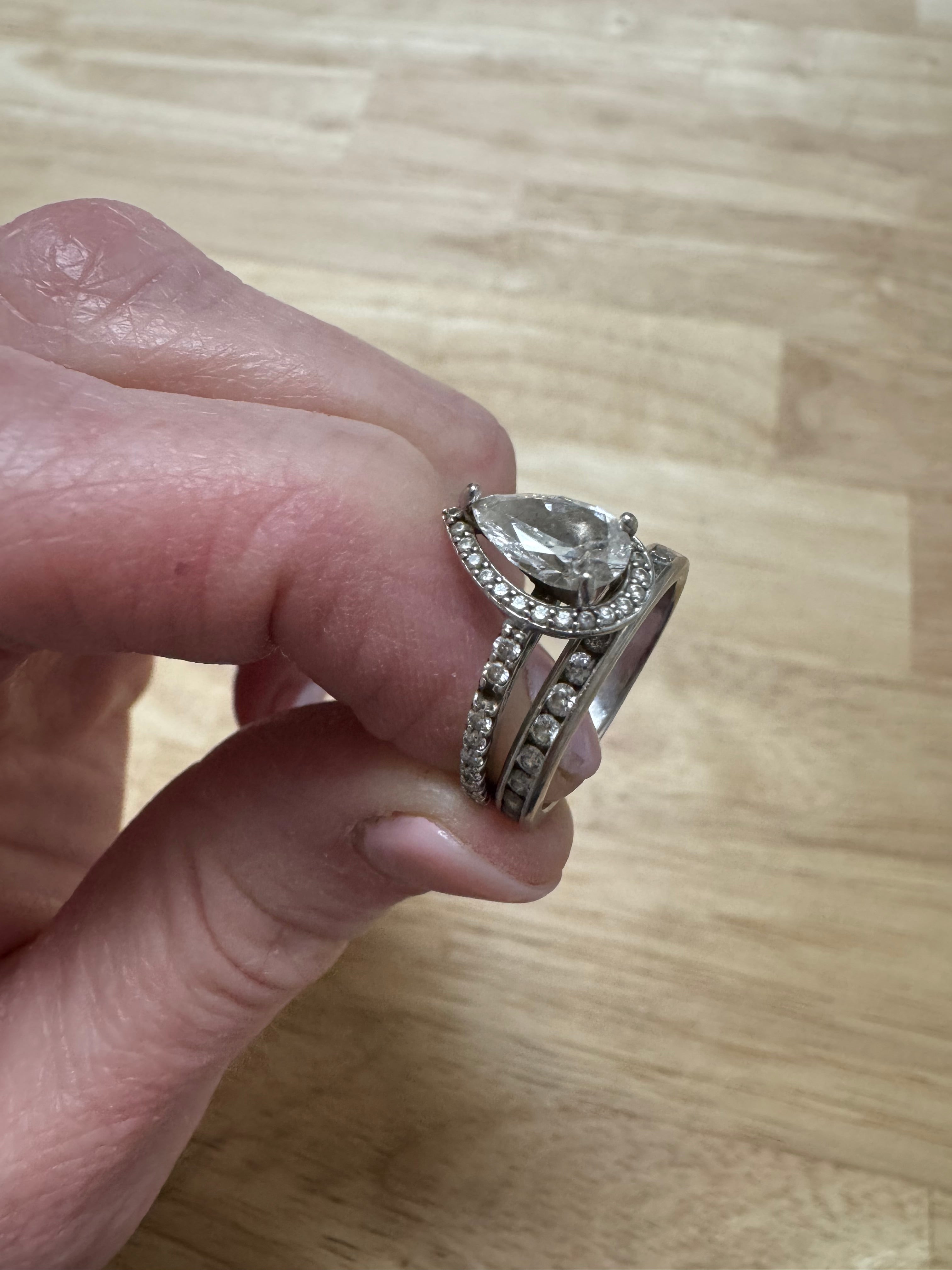 White gold diamond pear shaped halo engagement ring: round out and supply & set missing round diamond in shank. Rhodium/refinish.