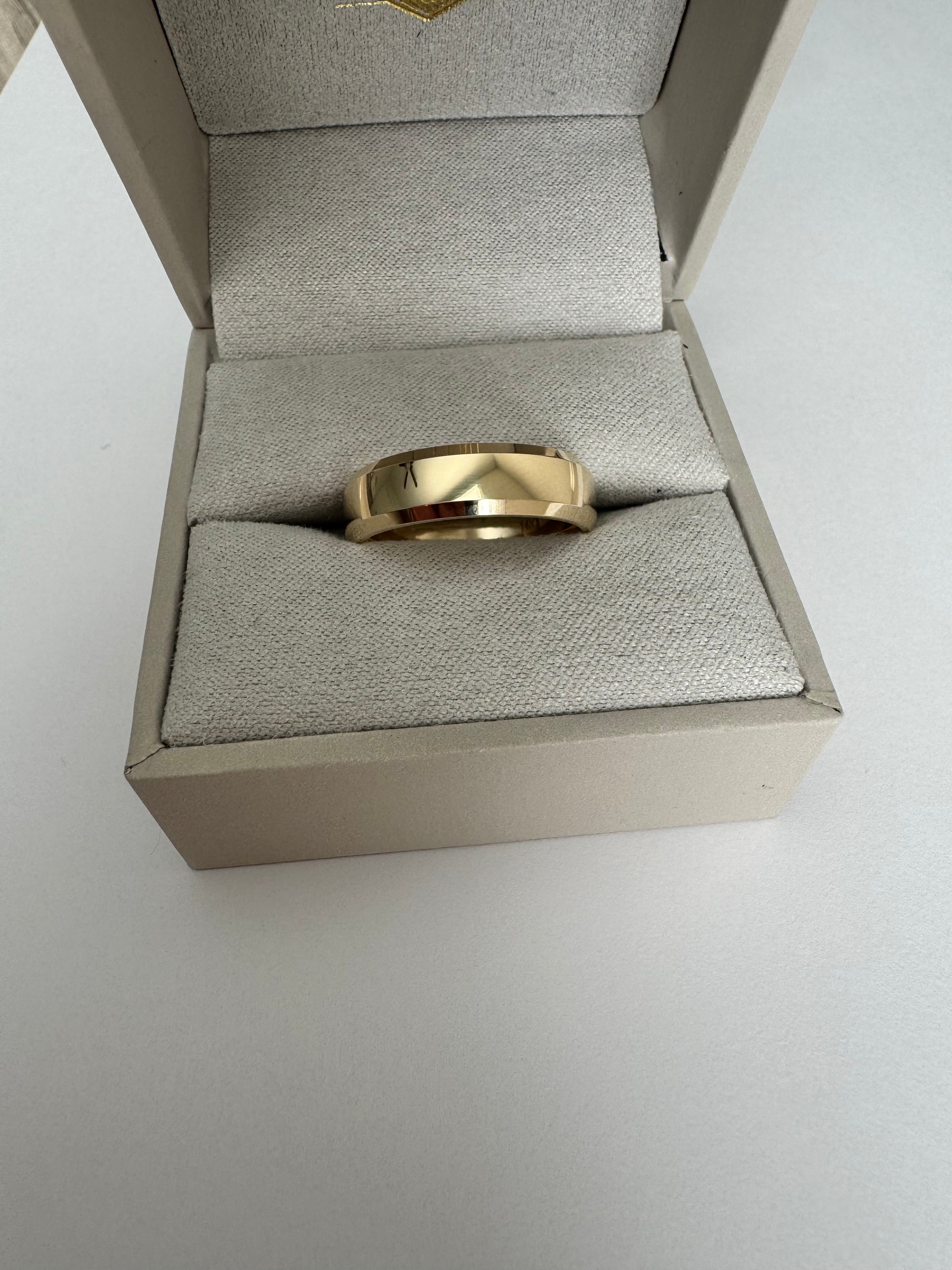 14k yellow gold, 6mm wide, comfort fit band. The ring has a half round, beveled edge detail. Size 9. 4.679 dwt.