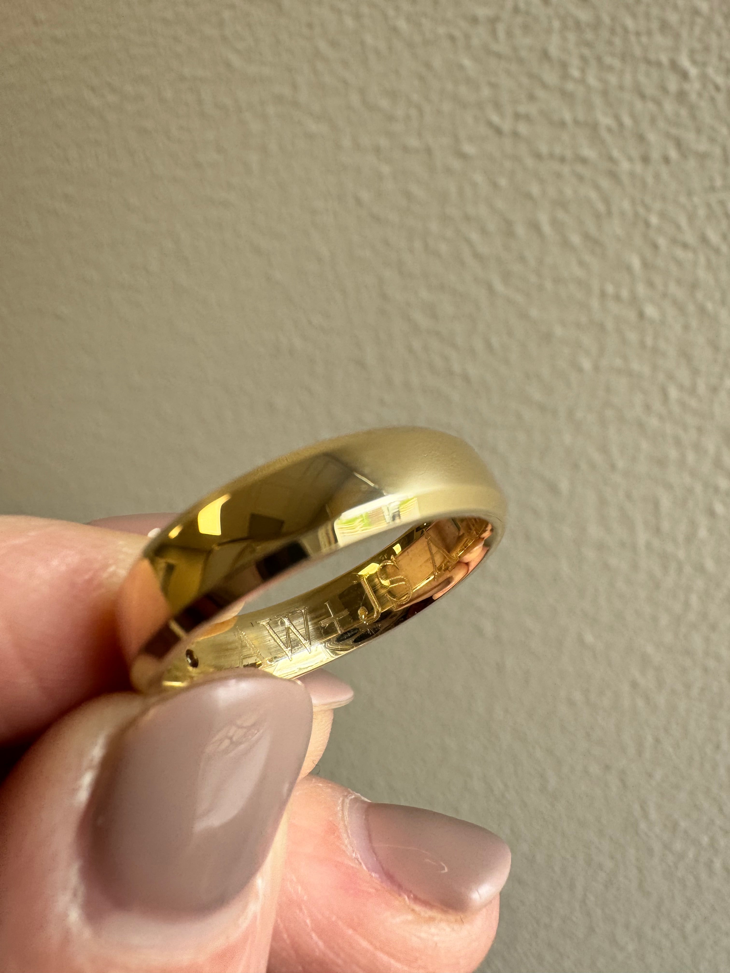 10k yellow gold 5mm wide, beveled edge half round wedding band with a 2mm genuine peridot (AA quality) flush set. Engraved on the inside in Bookman font: "AW+JS 05.23" There is a special character between the JS and the 05 (upside down V) Size 8.