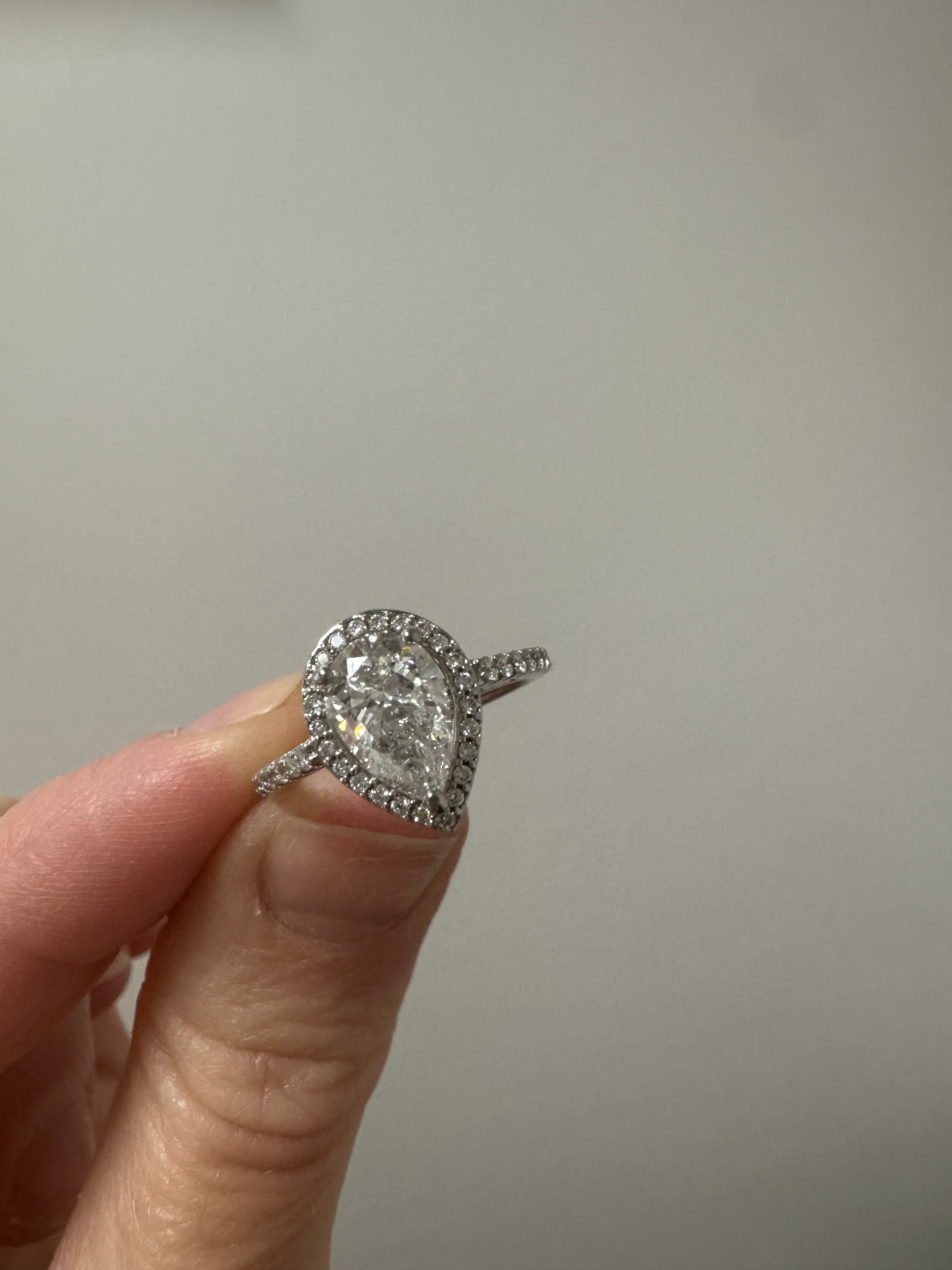White gold diamond pear shaped halo engagement ring: round out and supply & set missing round diamond in shank. Rhodium/refinish.