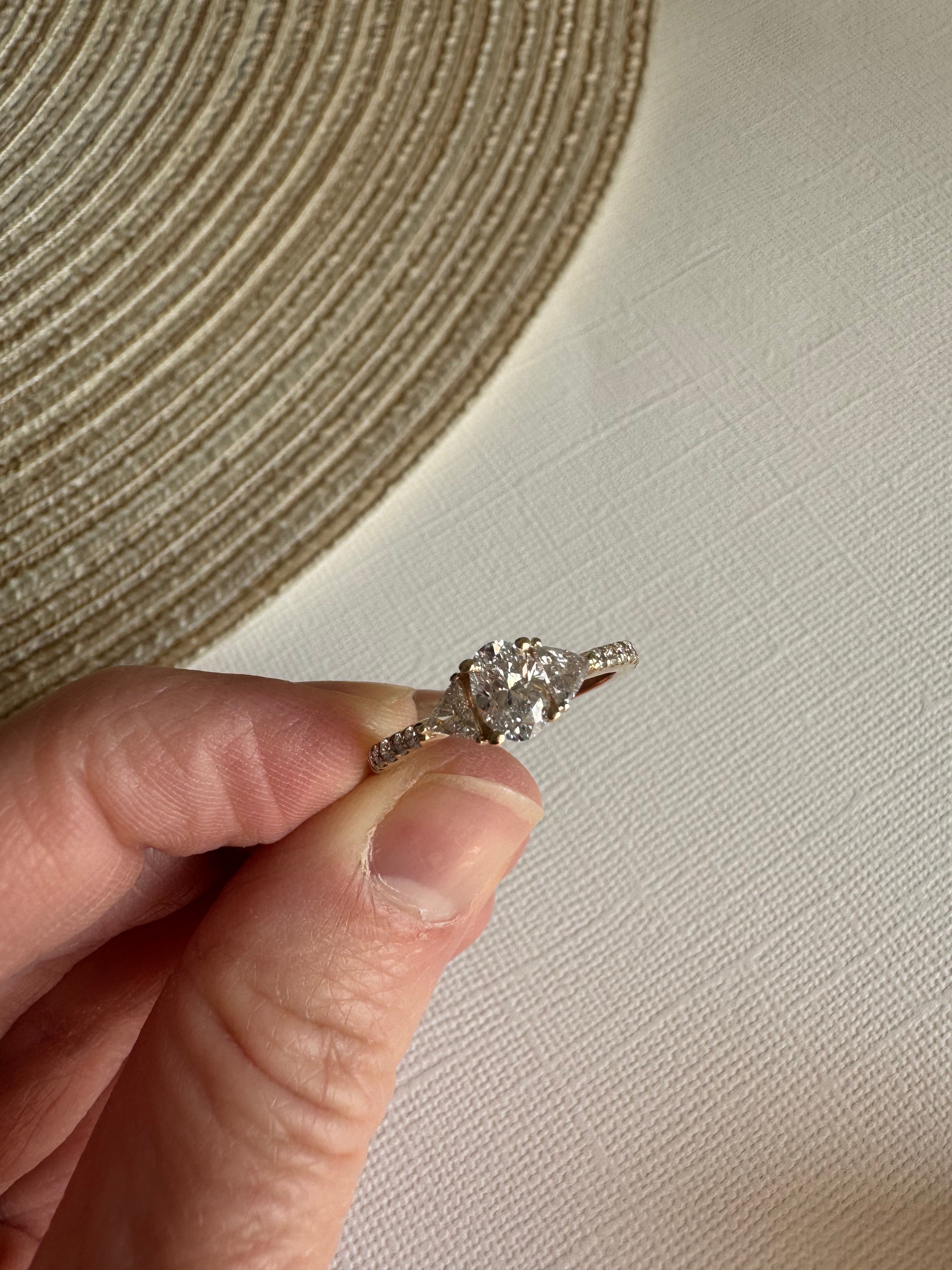 One custom 14k yellow gold diamond engagement ring using customer's 1, oval diamond & 2 triangle diamonds. Supplying 14 round natural diamonds totaling approximately