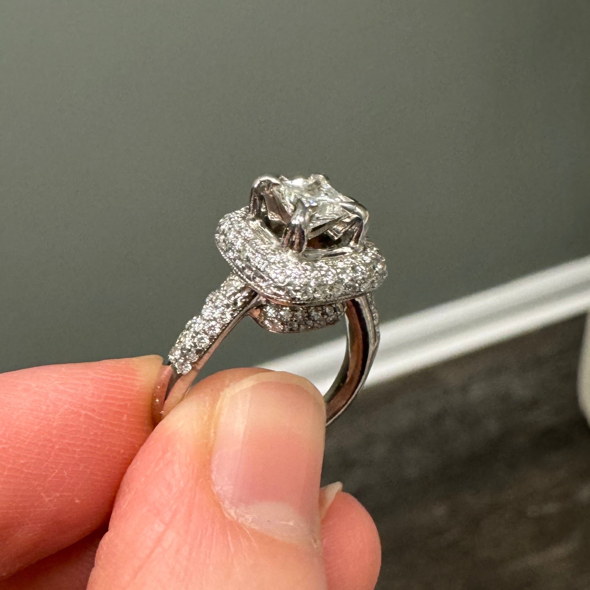 Repair: White gold pave set diamond engagement ring with princess cut center. Supply & set 2 missing diamonds & do 6 retips, polish & rhodium