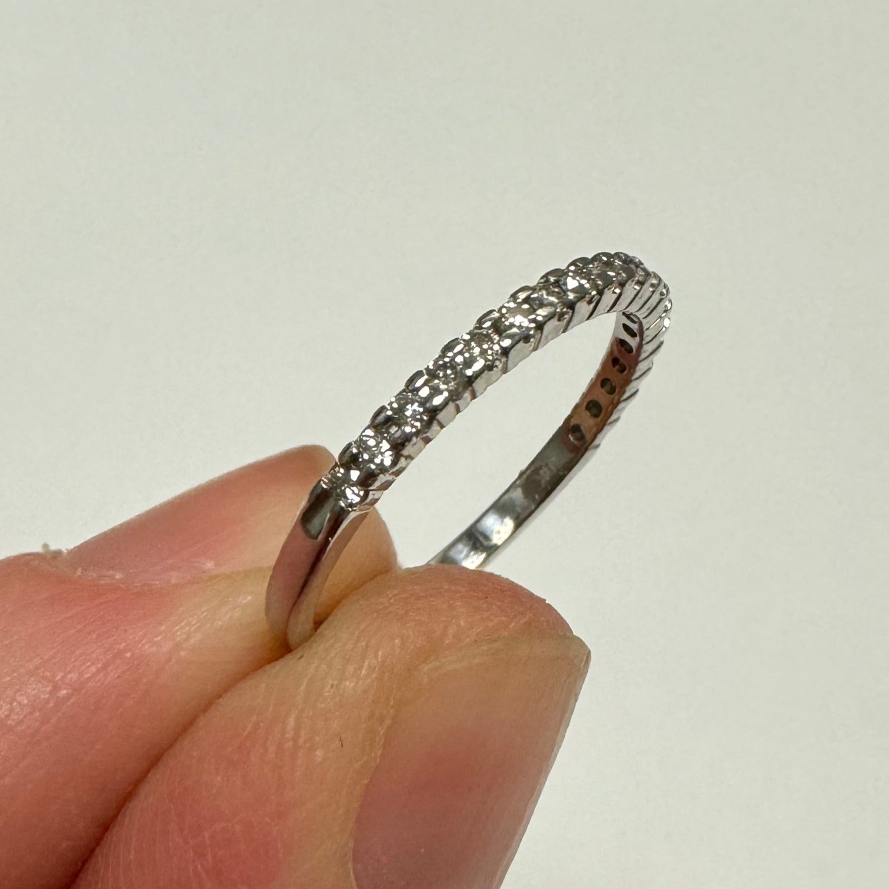 Repair: 10k white gold shared prong diamond band. Size down to 4.75, clean, polish & rhodium
