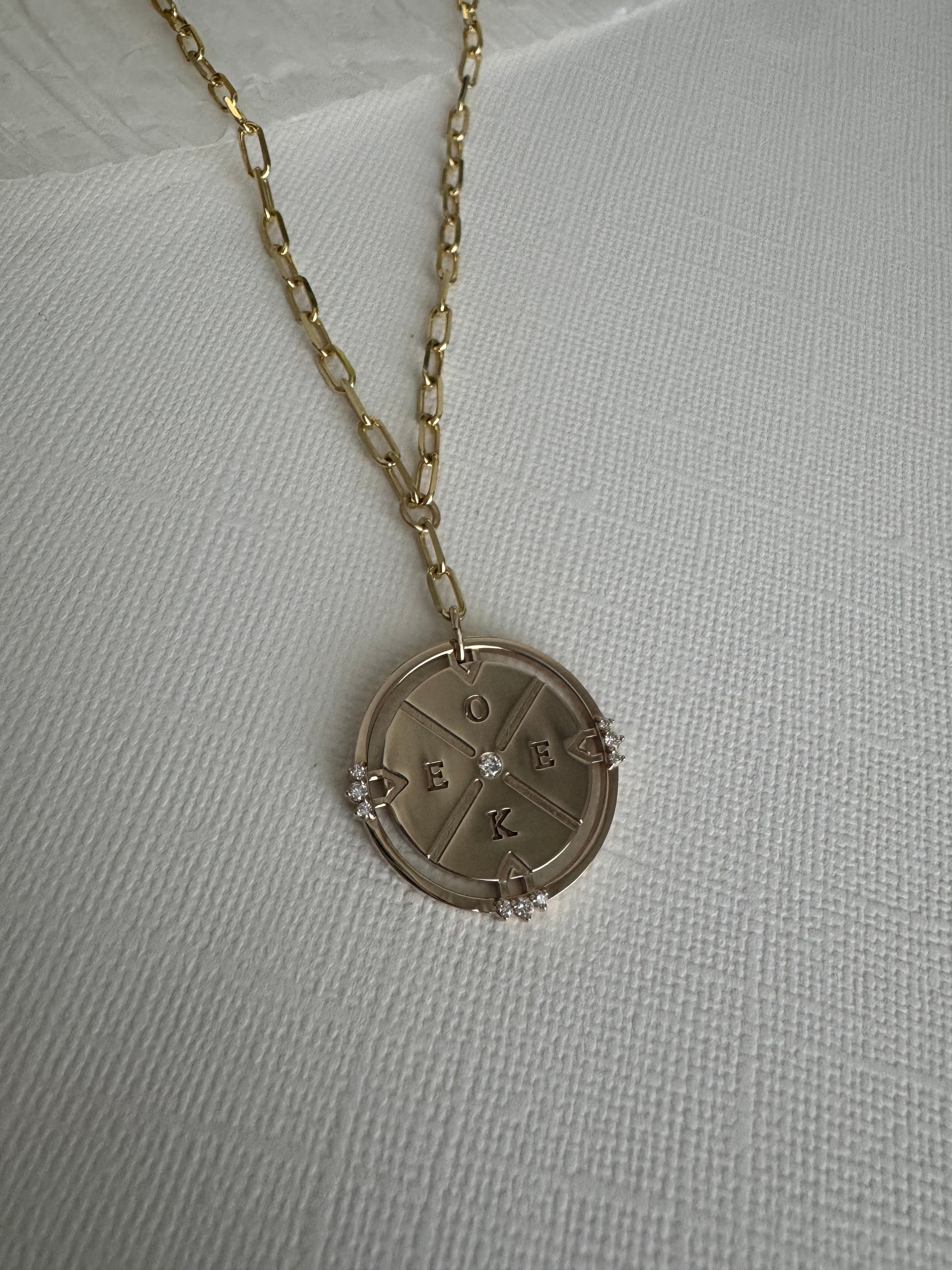 14k yellow gold compass necklace on a 22" paper clip chain with initials O, E, E, K and 10 round natural diamonds