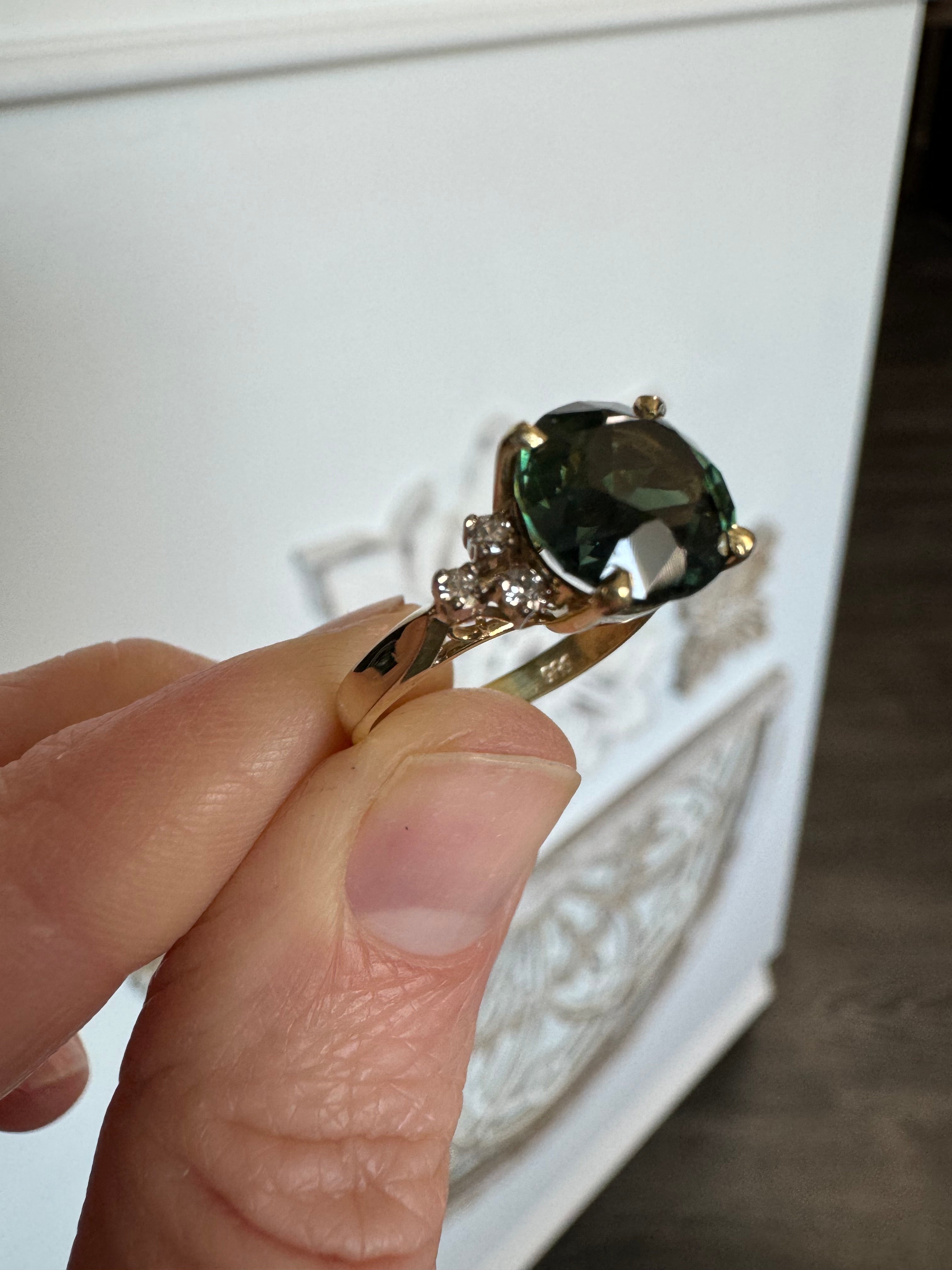 Size customer's 14k yellow gold diamond ring with a green center gemstone down to a 5