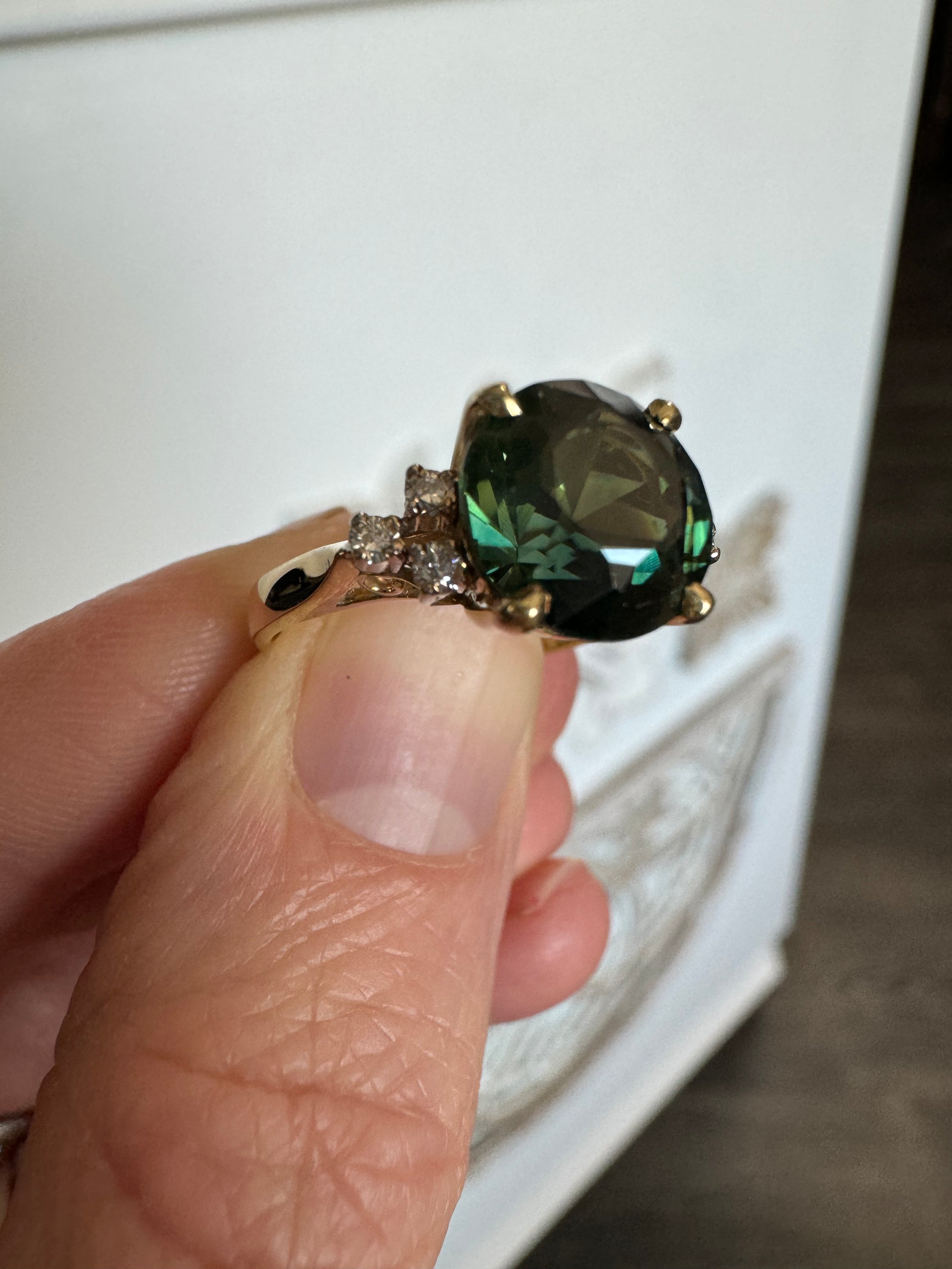 Size customer's 14k yellow gold diamond ring with a green center gemstone down to a 5