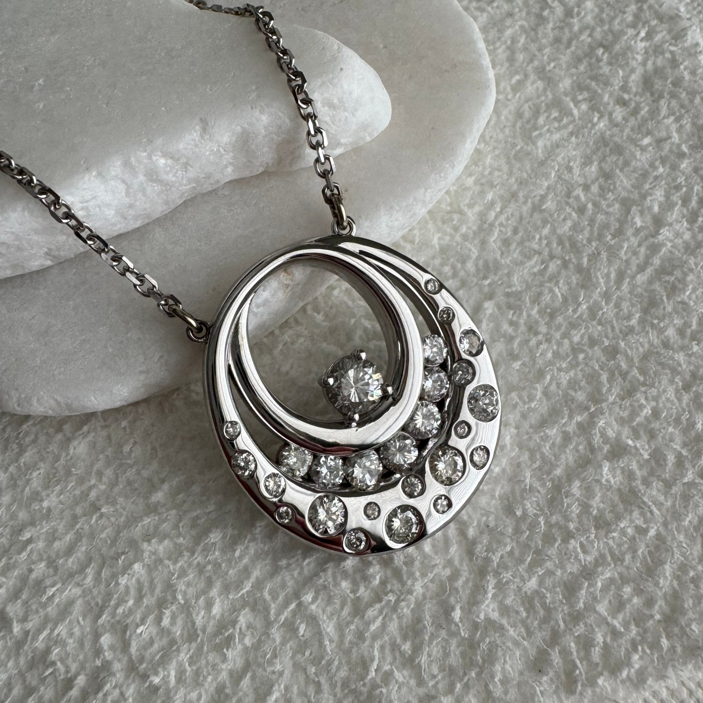 Custom 14k white gold circle swirl style necklace using customer's diamonds on an 18", 1.8 mm diamond cut cable chain