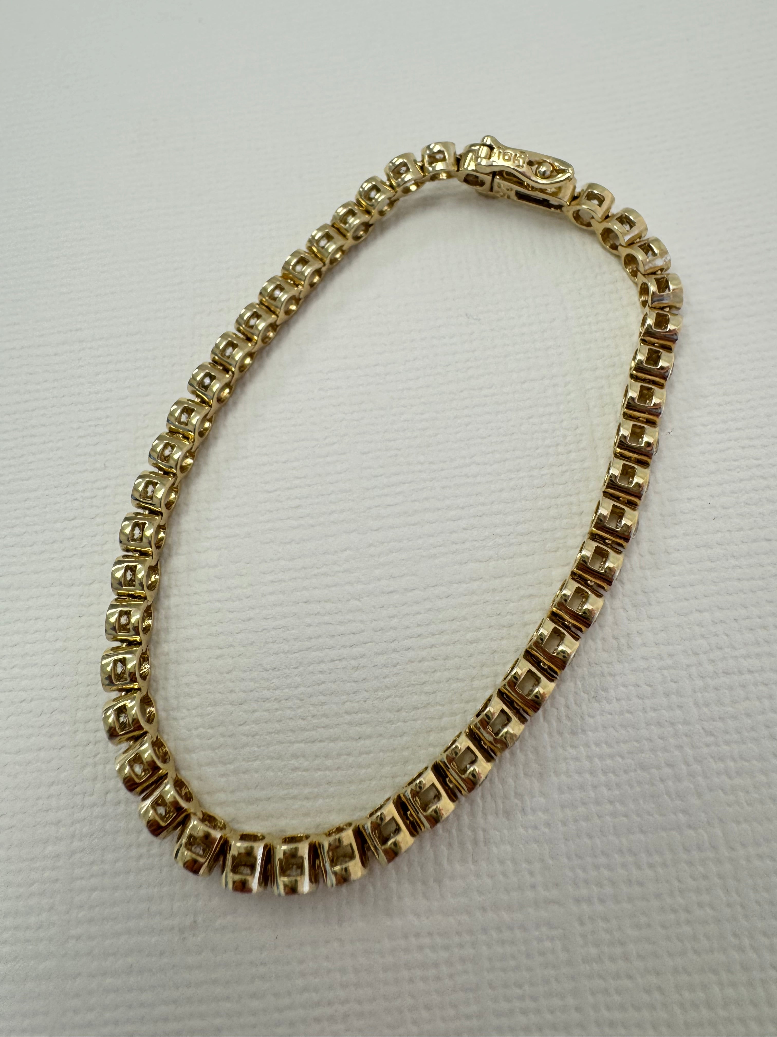 10k yellow gold bezel set diamond tennis bracelet using client's 43, 2.5mm diamonds. Approx 2.58 cttw. (Client has 12 leftover diamonds & we removed 4 links from the bracelet)