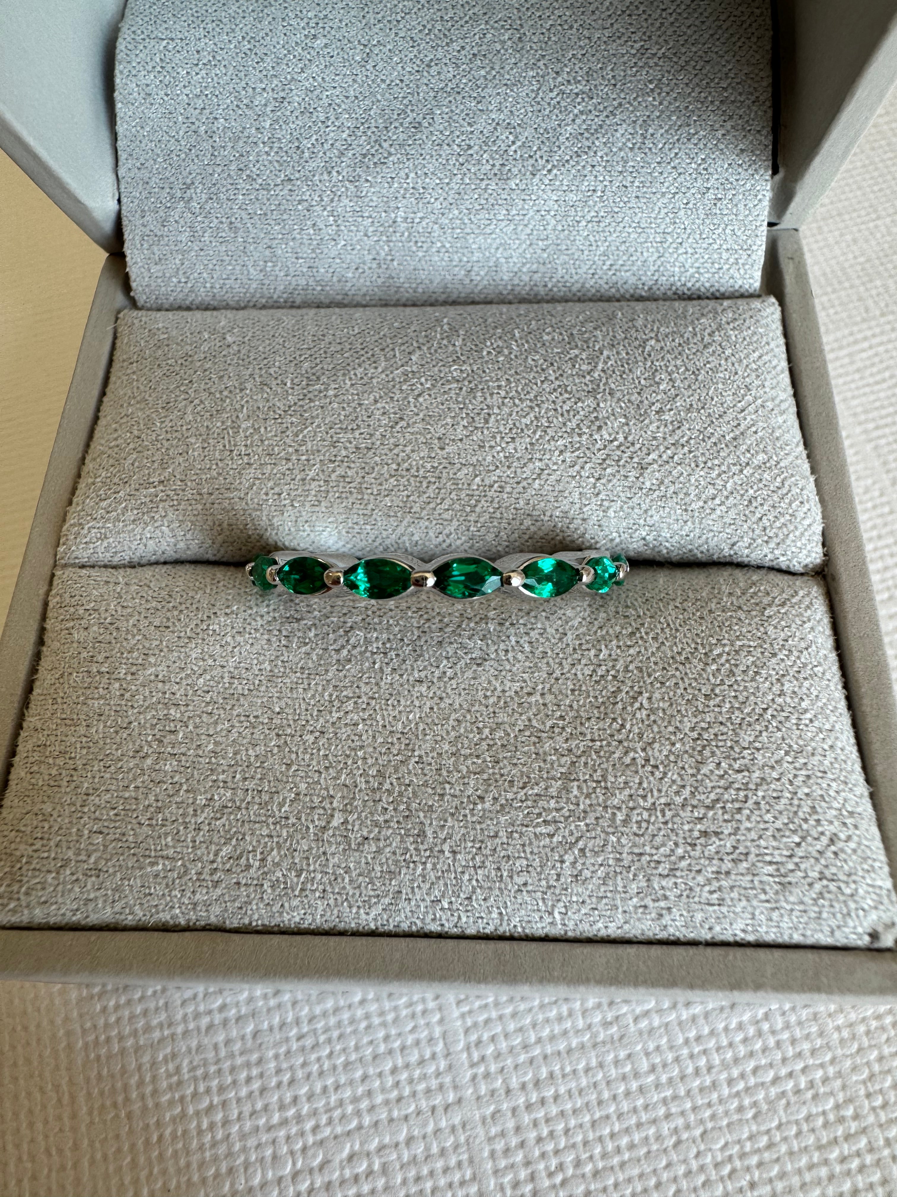 Custom, 14k white gold band with 8, lab grown marquise shaped emeralds (4x2mm) totaling approx. .48 carats. Size 7.5.
