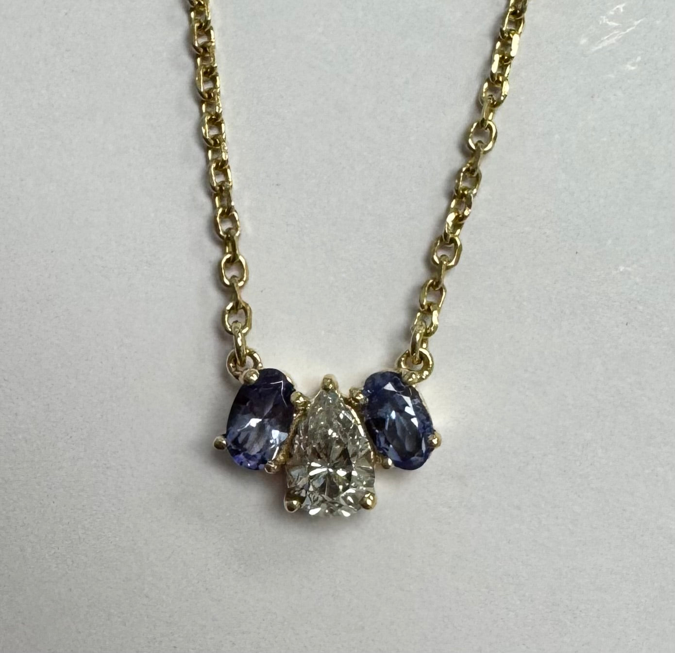 Yellow gold tanzanite & diamond necklace: set supplied oval tanzanite & retip 2 inner top prongs on tanzanites. Polish. No charge.