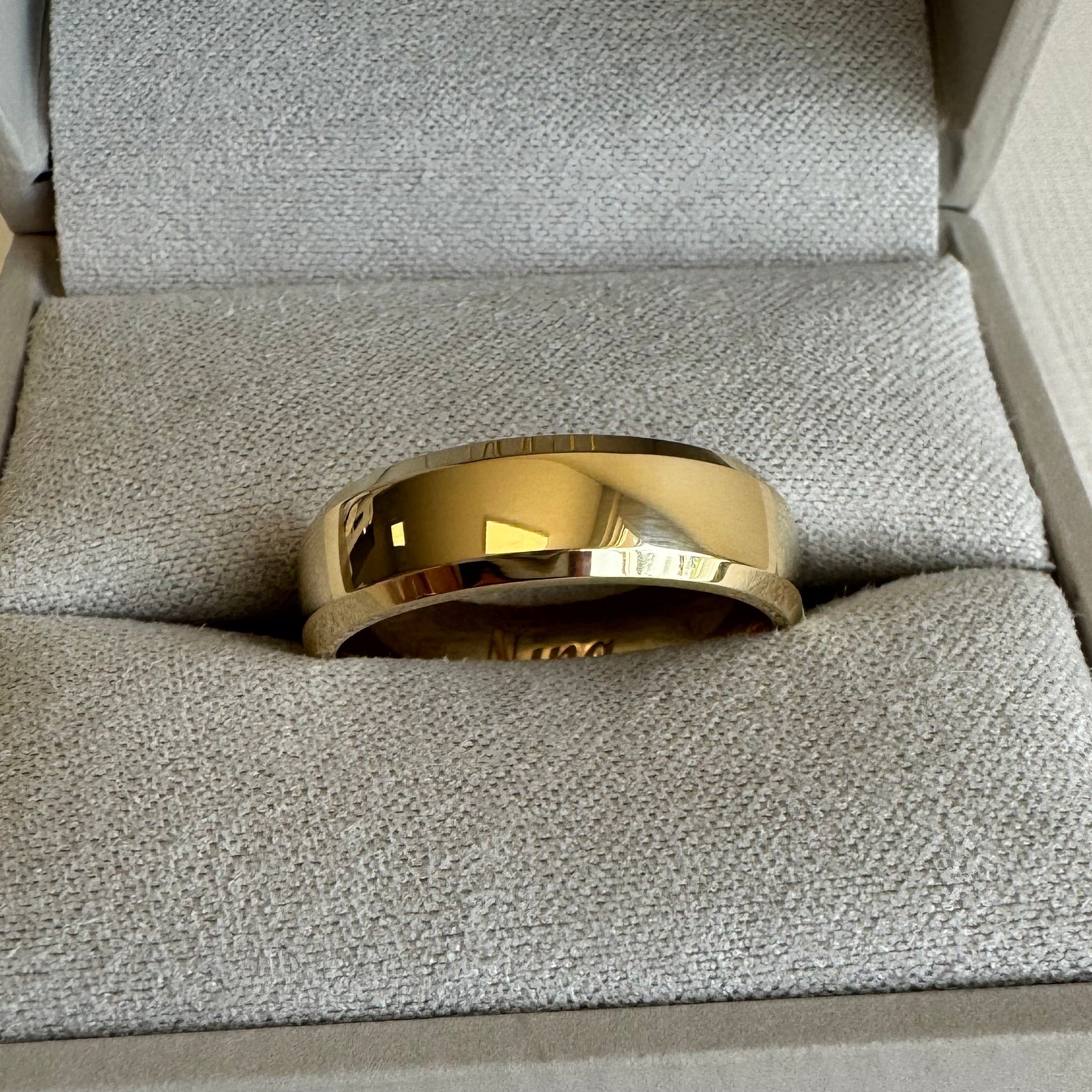 10K Yellow Gold, 6 mm Beveled-Edge, Comfort-Fit, Half Round Band. Size 8.5. The inside is engraved with "Nina" in a Script MT Bold font.