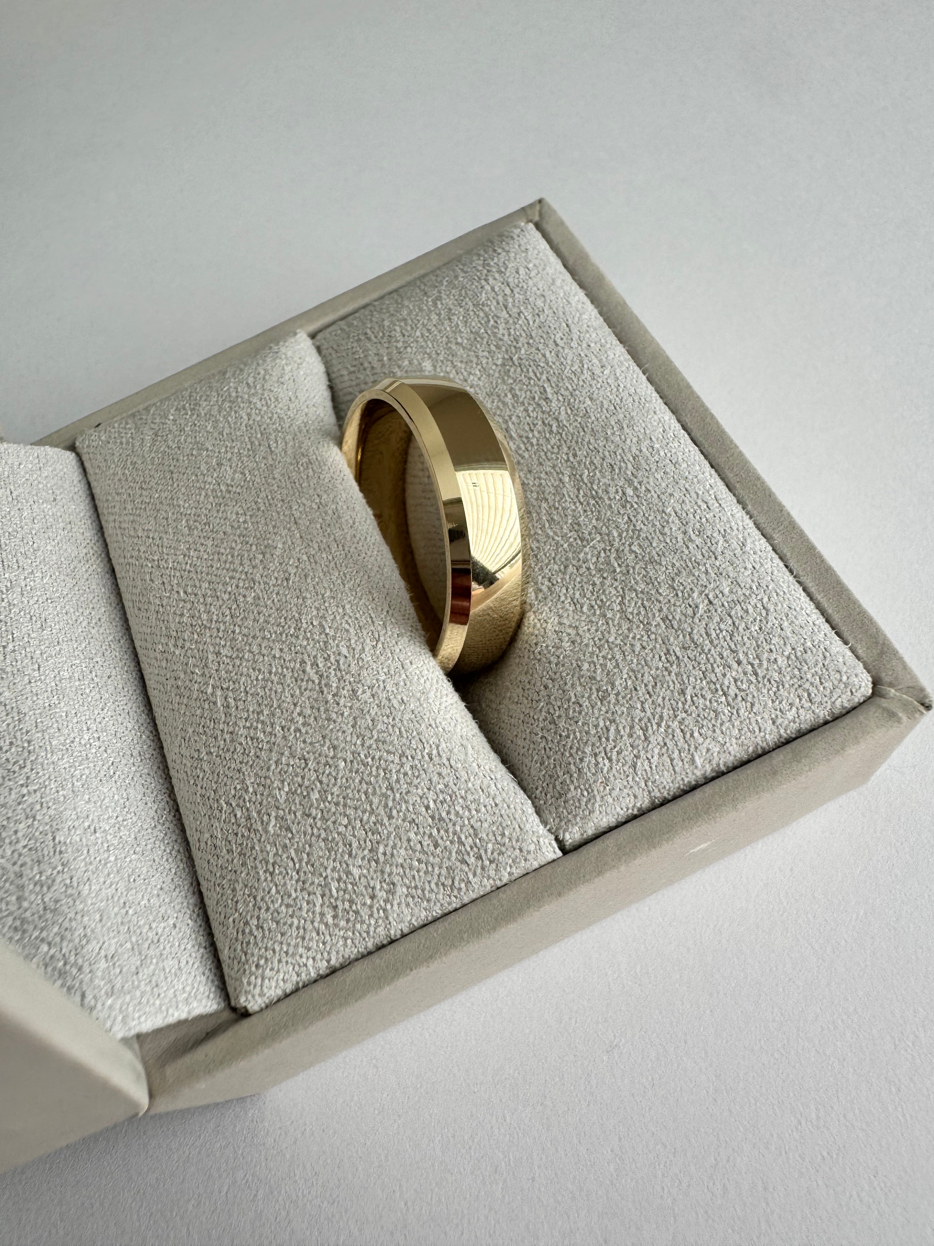 14k yellow gold, 6mm wide, comfort fit band. The ring has a half round, beveled edge detail. Size 9.  4.679 dwt.