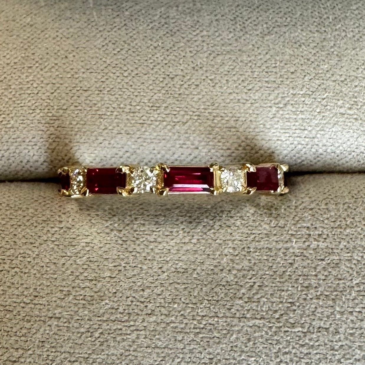 Custom 14k yellow gold, engraved,wedding band with 5, 4x2mm straight baguette natural AA quality rubies and 4, 2mm round brilliant cut natural diamonds. Size 5.5. (Rubies= approx. 0.85cts. Dias= approx. 0.12 cts)