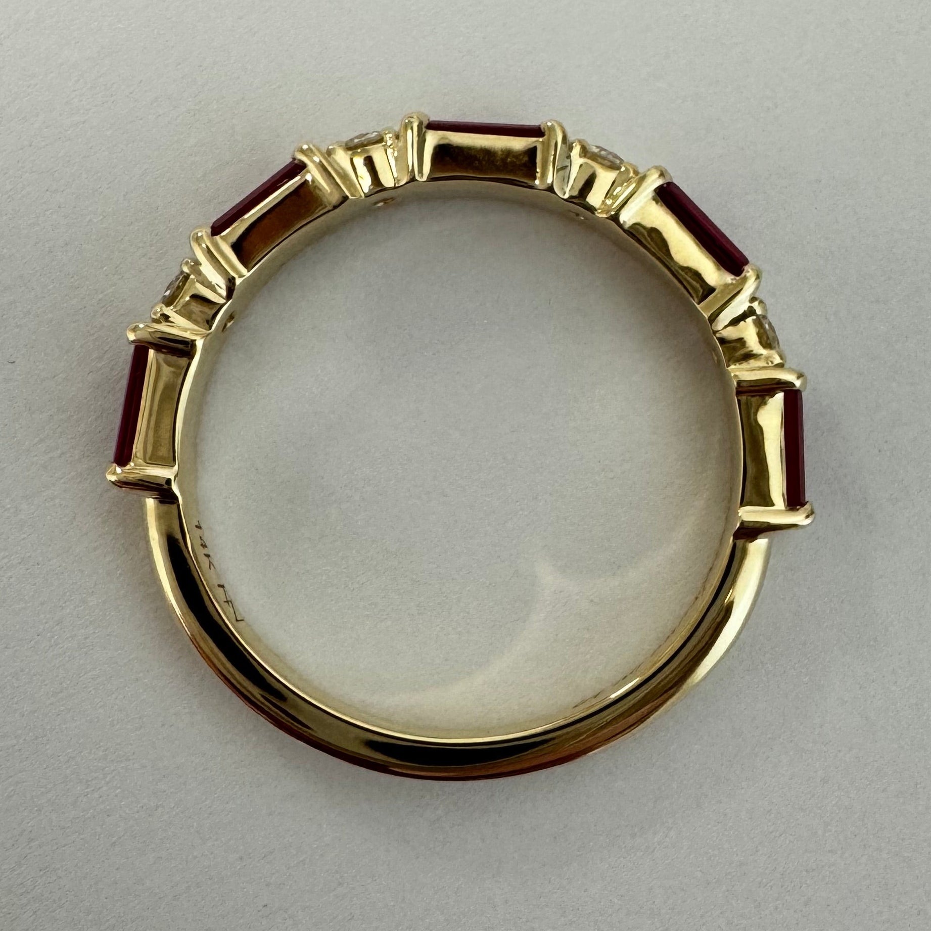 Custom 14k yellow gold, engraved,wedding band with 5, 4x2mm straight baguette natural AA quality rubies and 4, 2mm round brilliant cut natural diamonds. Size 5.5. (Rubies= approx. 0.85cts. Dias= approx. 0.12 cts)