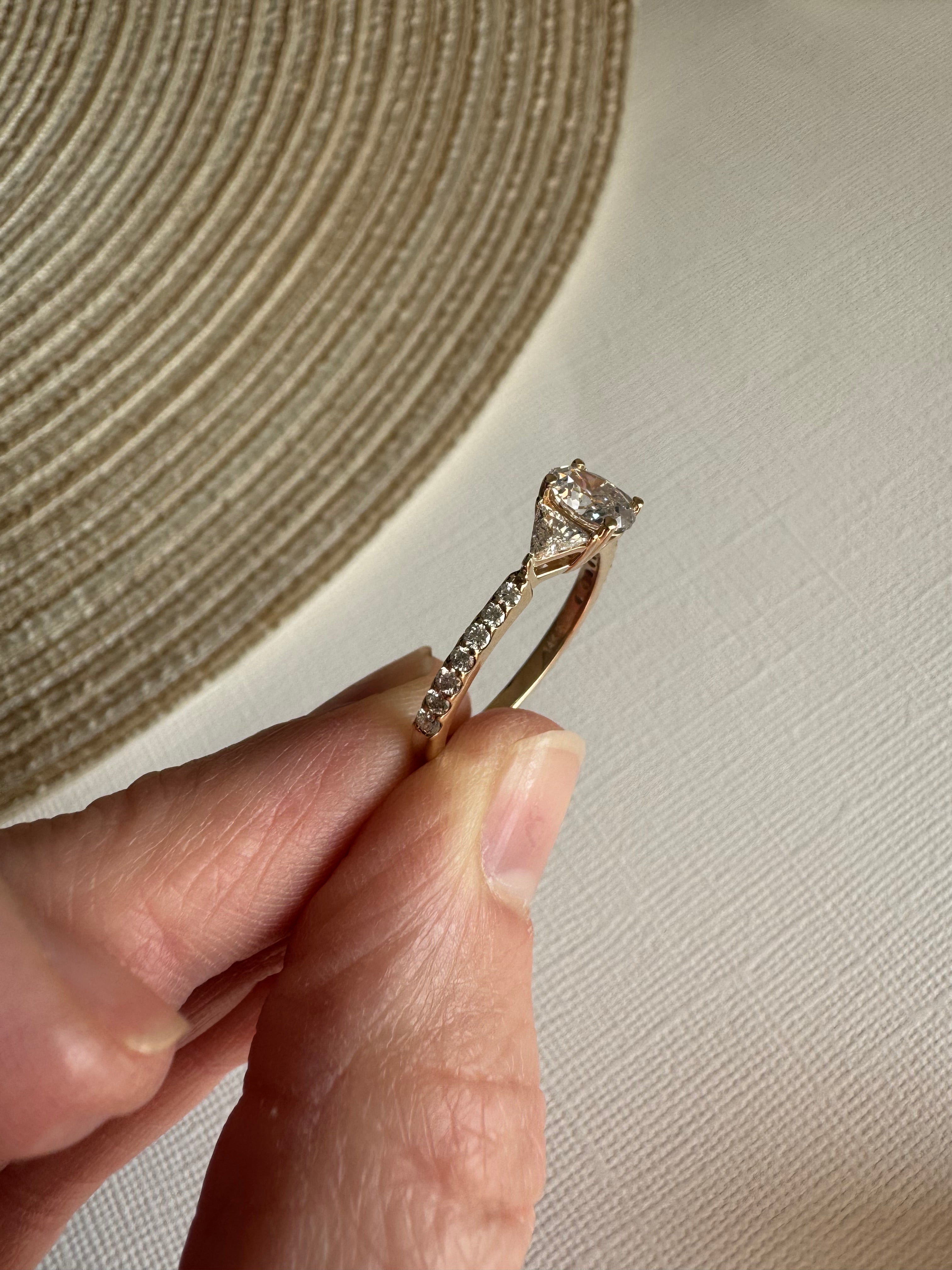 One custom 14k yellow gold diamond engagement ring using customer's 1, oval diamond & 2 triangle diamonds. Supplying 14 round natural diamonds totaling approximately