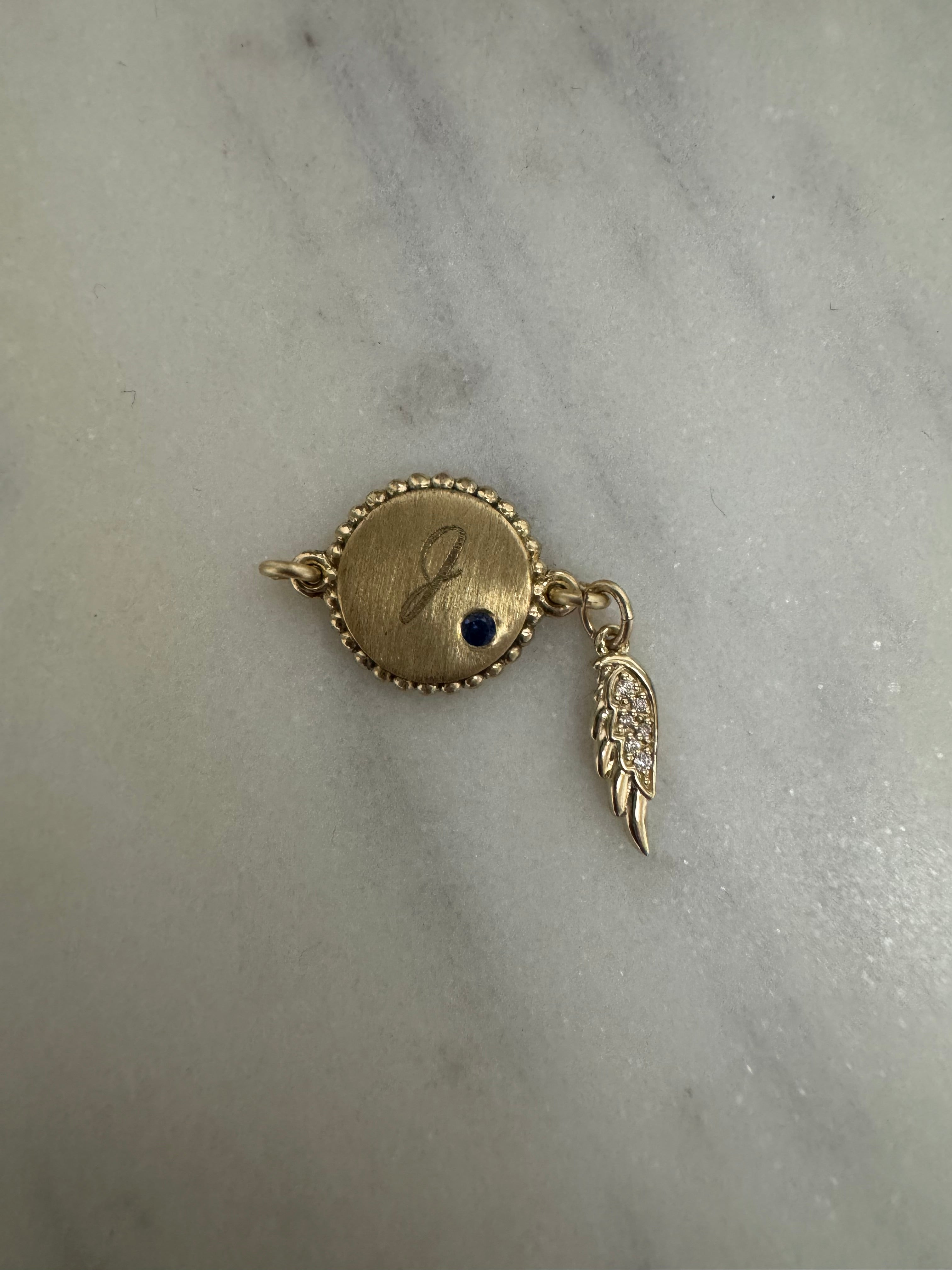 14k yg disc charm with engraved "J" and flush set  1.75mm genuine A quality sapphire on each side, 14k yg diamond angel wing charm, 14k yellow gold lobster clasp.