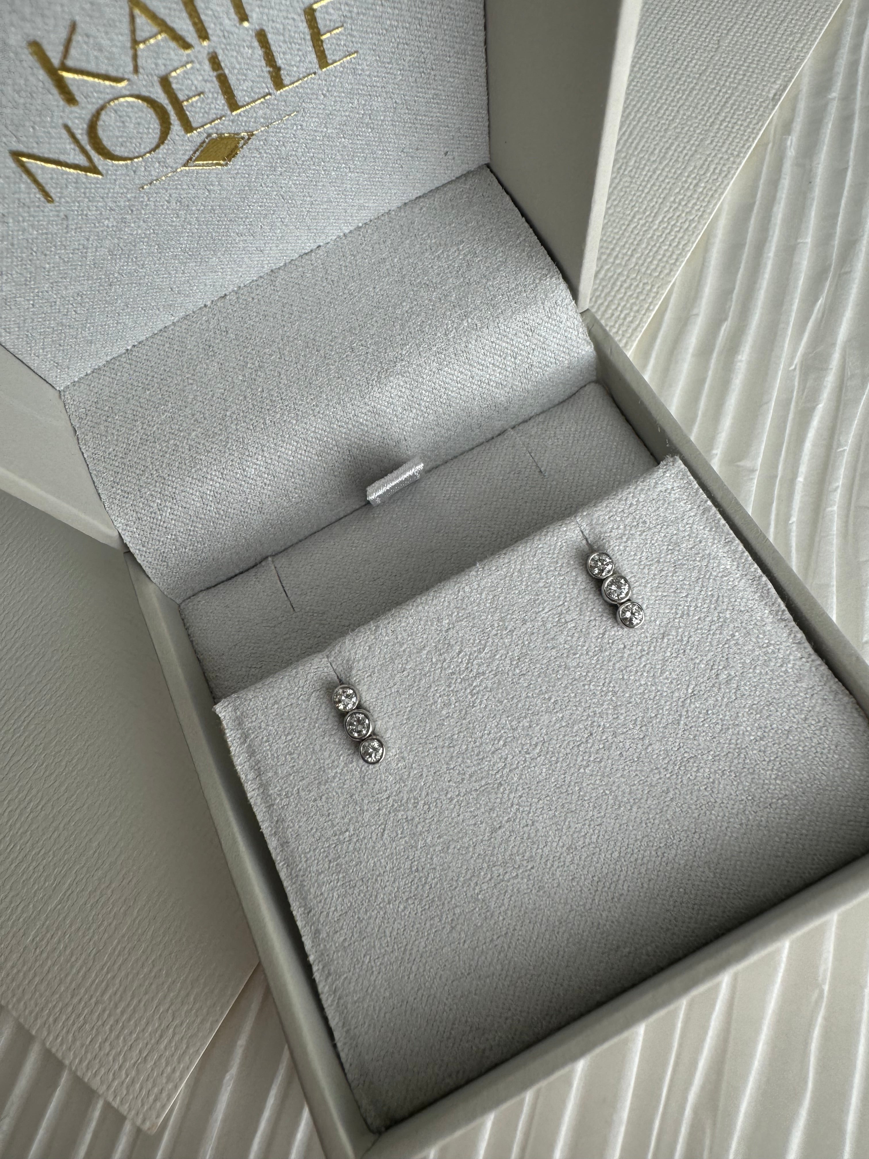 14k white gold diamond bezel earrings. Each earring set with 3 of customer's round diamonds.