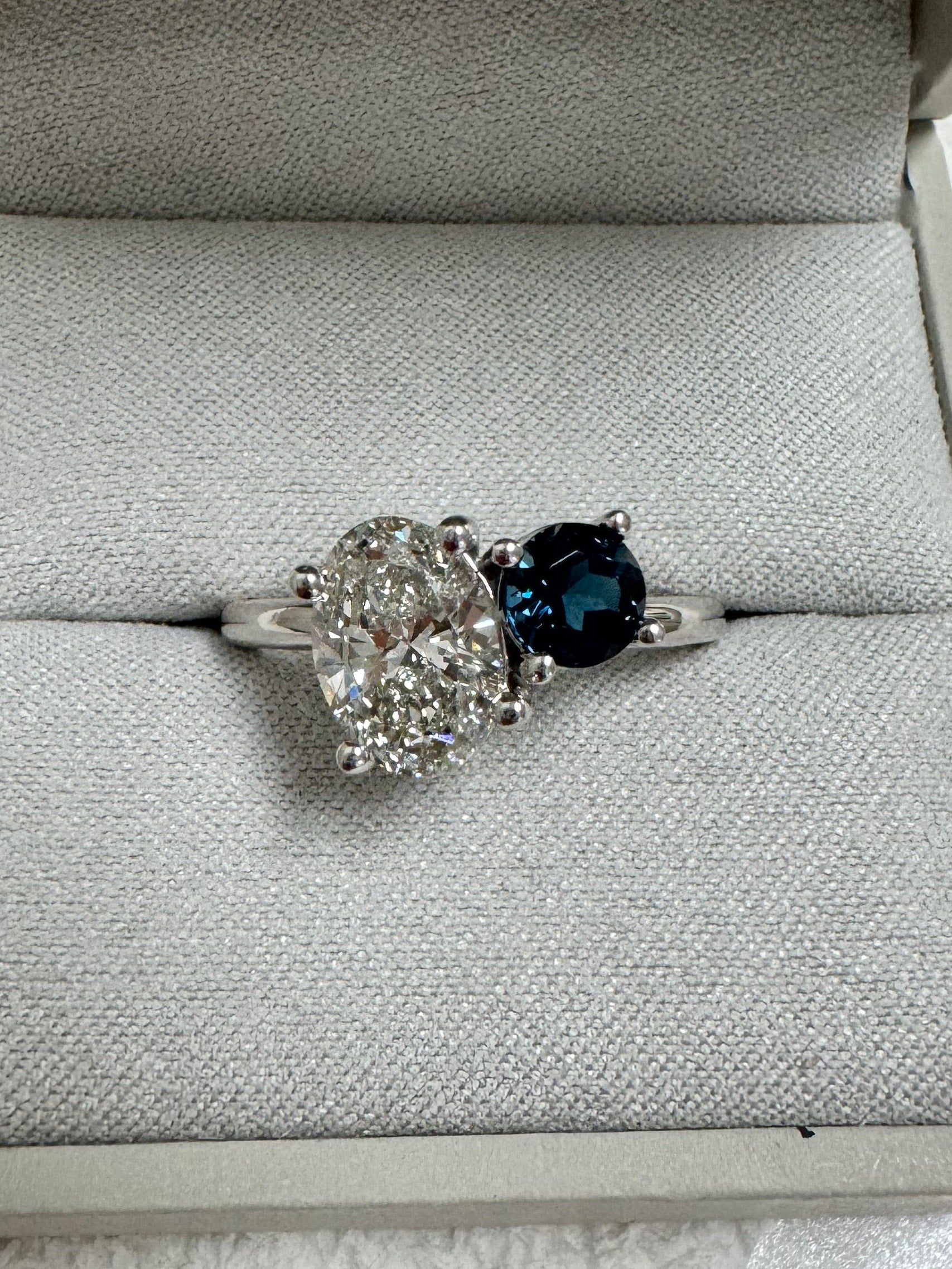 Custom 14k white gold 2 stone ring using customer's 2ct. oval lab grown diamond & supplying 1, 5.5mm round AA quality London Blue Topaz. Size 9.